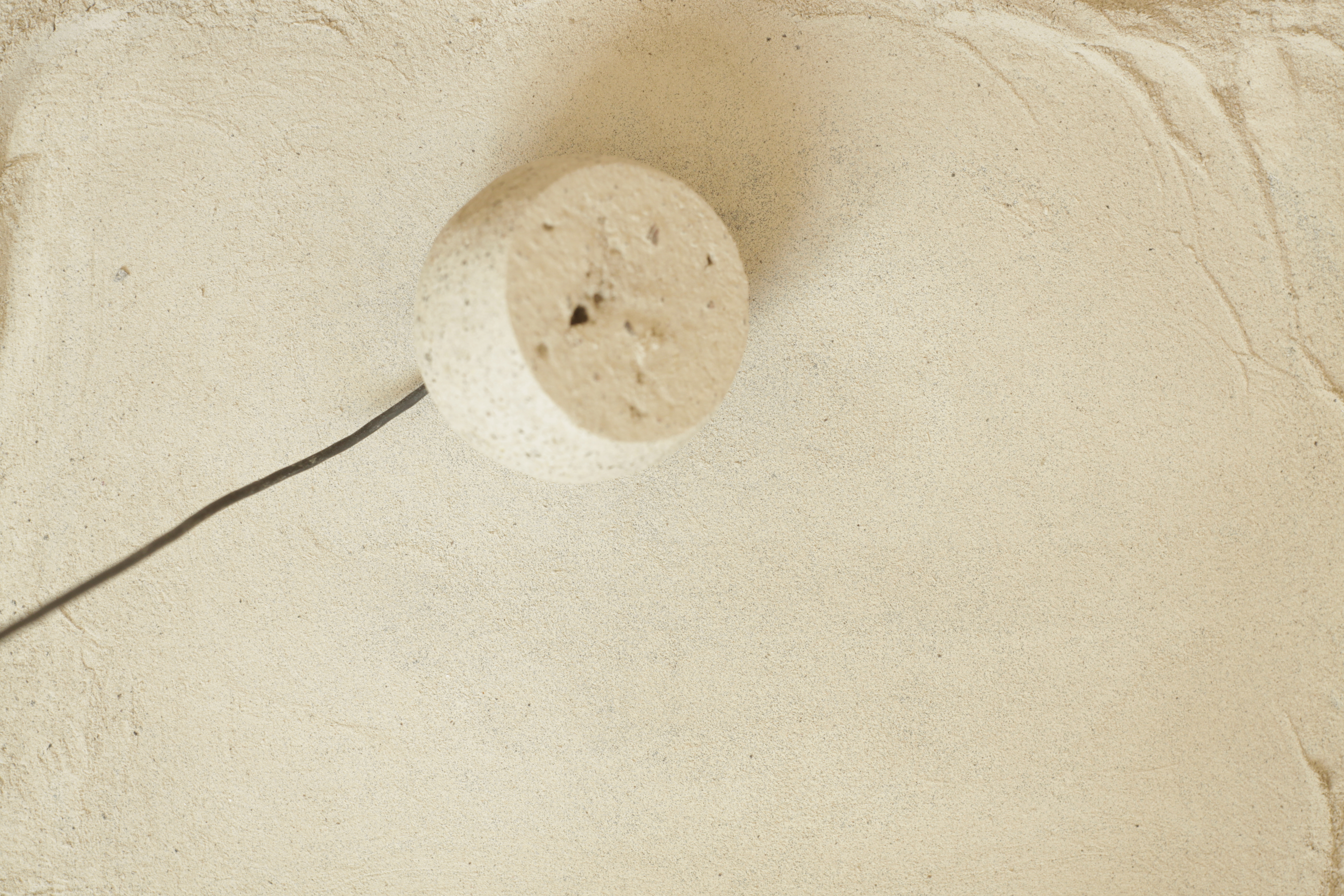 Interior of a ceramic globe with a microphone inserted into it.